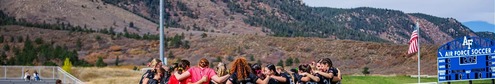 The women's soccer team huddles at Cadet Soccer Stadium before a game.