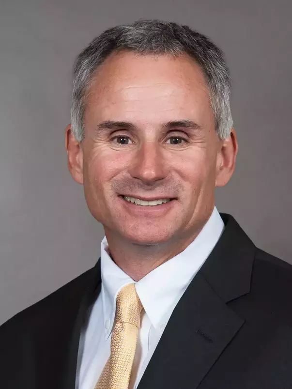 Assistant Coach John Loose headshot with a suit and tie on.