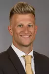 Offensive Coordinator Cody Worley headshot in a suit and tie.