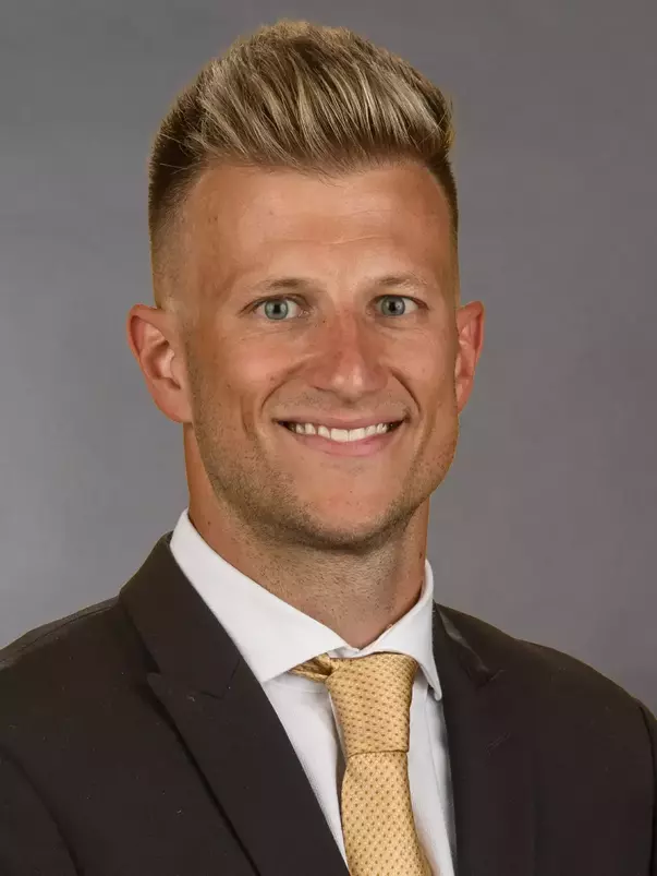 Offensive Coordinator Cody Worley headshot in a suit and tie.