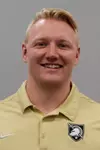 Assistant Coach Seth Hestness headshot with a gold polo shirt.