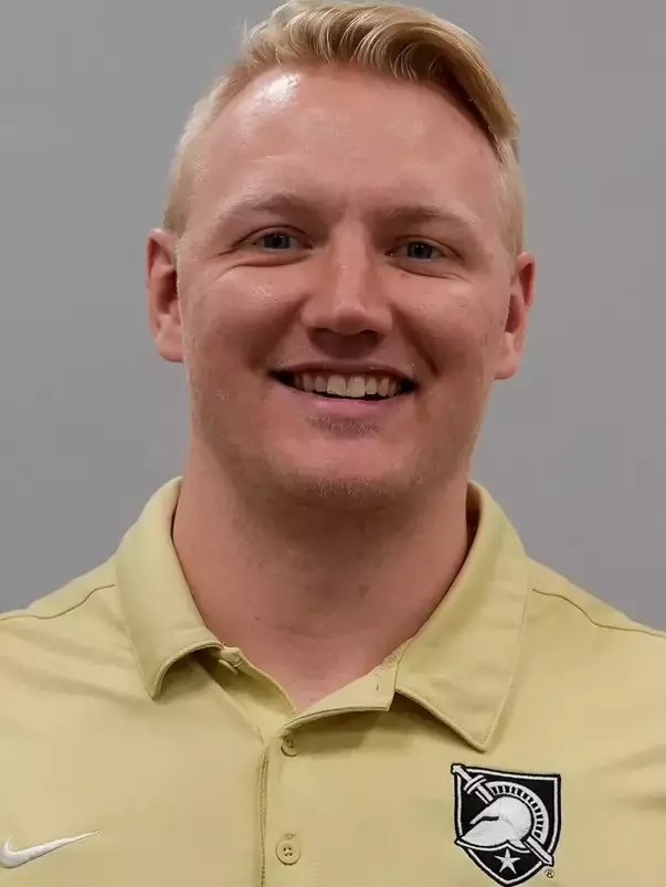 Assistant Coach Seth Hestness headshot with a gold polo shirt.