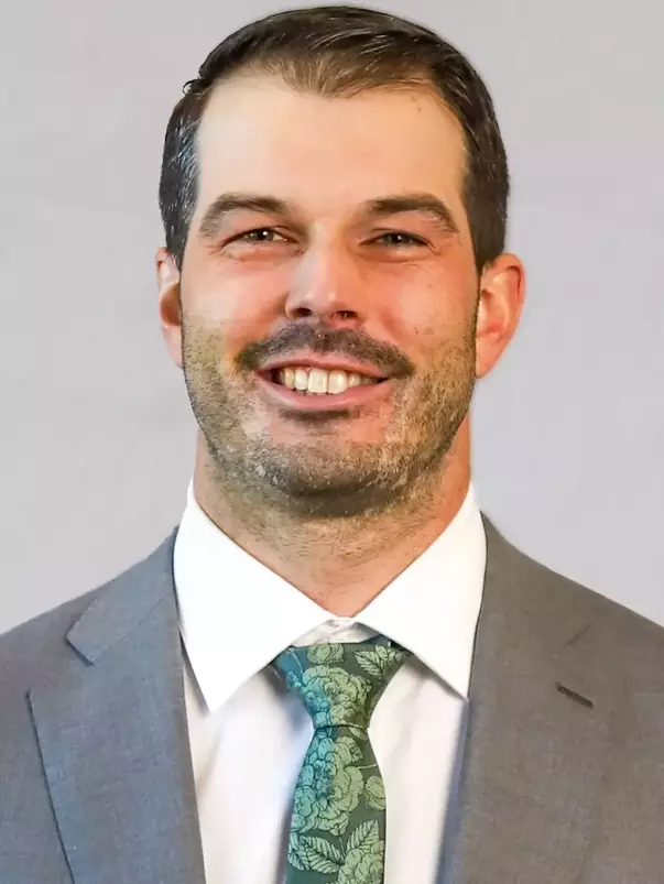 Ian Moore headshot with a suit and tie on.