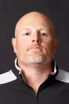 Assistant Coach John Holt Headshot with a black polo on.