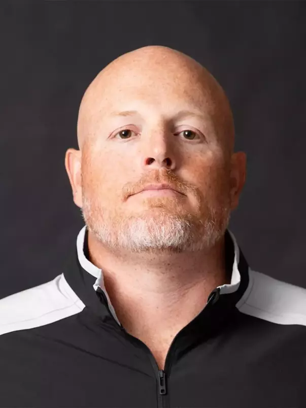 Assistant Coach John Holt Headshot with a black polo on.