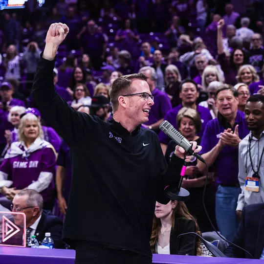 Mark Campbell holds a microphone as he addresses the crowd following an NCAA Tournament win