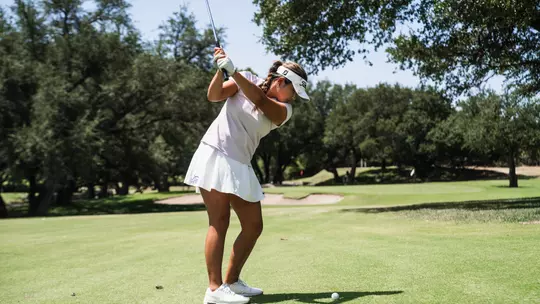 Kirstin Angosta progresses through her back swing wearing a lavender shirt