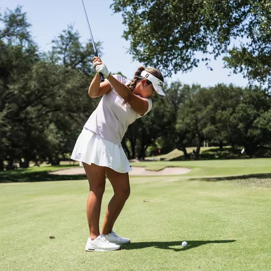 Kirstin Angosta progresses through her back swing wearing a lavender shirt