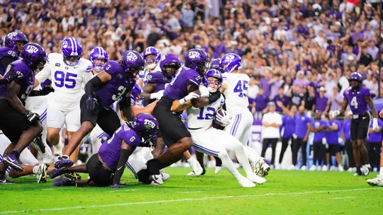 TCU's defense swarms the BYU runner.