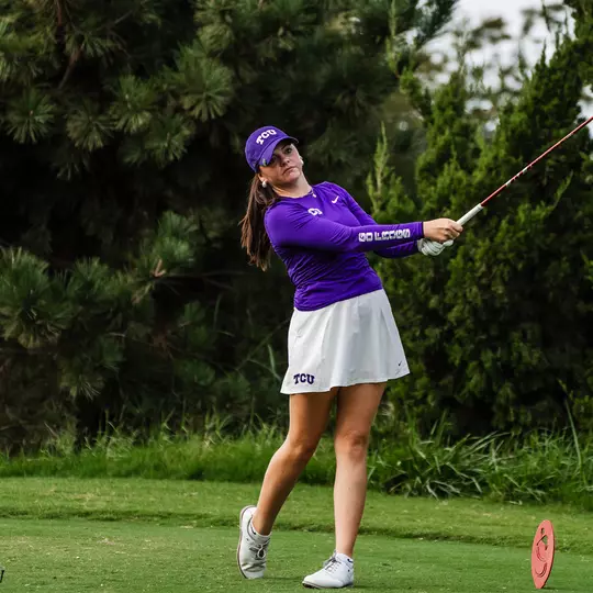 Gracie McGovern holds her follow through on a tee shot wearing a purple long-sleeve shirt