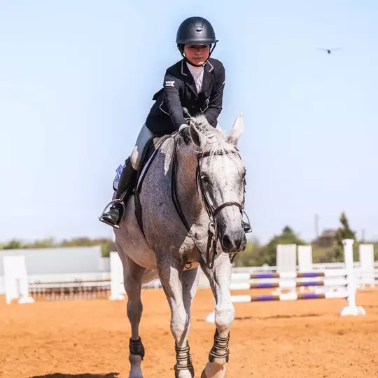 Lily Muzzy petting a horse
