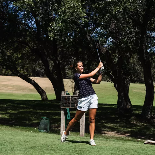Ella Forss follows through on a tee shot wearing a black polo