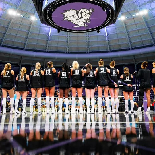 TCU Volleyball players stand on the baseline for the national anthem.