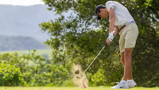 Sam Udovich makes contact with the ball hitting an iron off the tee box.