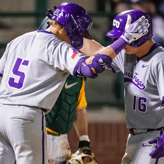 Lucas Franco and Nolan Traeger tap helmets at home plate after Traeger's home run.