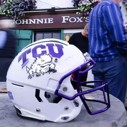 White TCU football helmet on top of a table in front of Johnnie Fox's.