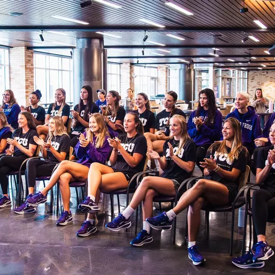 TCU beach volleyball team clapping at the NCAA Selection Show party
