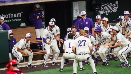 Jack Bell celebrates with his teammates in front of the dugout after a home run.