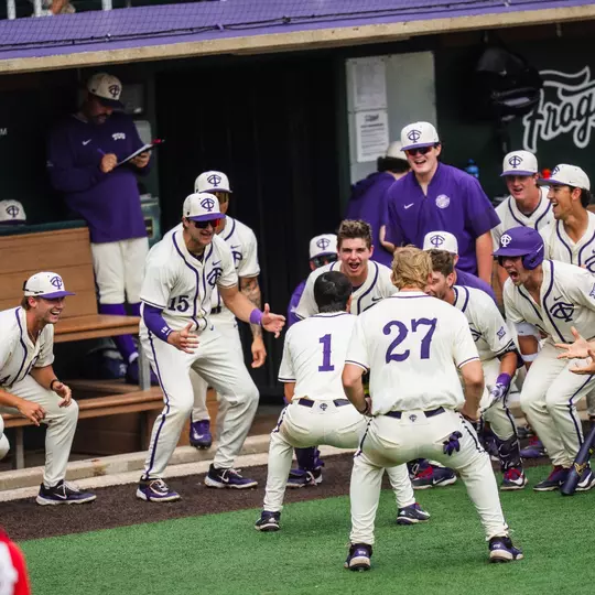 Jack Bell celebrates with his teammates in front of the dugout after a home run.