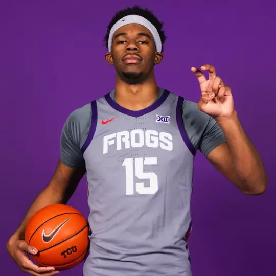 DJ Thomas poses with a grey jersey on the purple background.