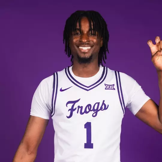 Luke Bamgboye poses in a white uniform against a purple background.