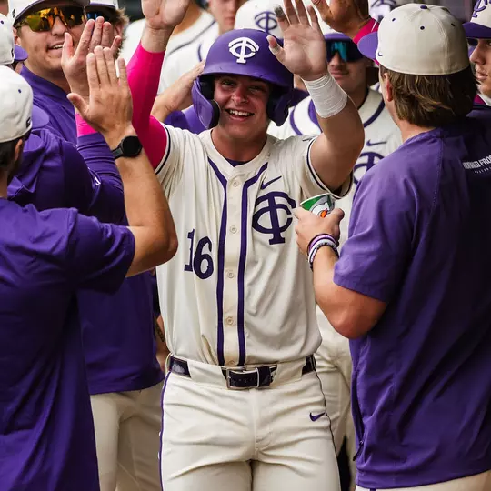 Nolan Traeger receives congratulations from his teammates in the dugout.