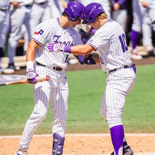 Chase Brunson and Sawyer Strosnider tap helmets at home plate.