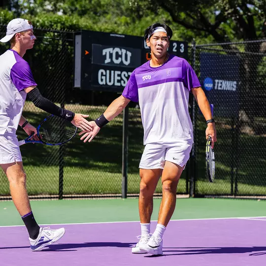 Cosme Rolland De Ravel and Duncan Chan high five during a doubles match.