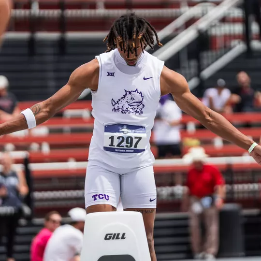 TCU's Ronnie Kendrick standing behind the starting block with his arms outstretched