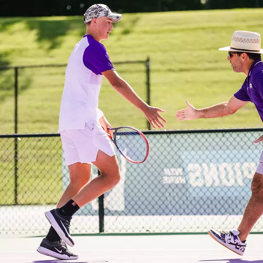 Maximus Dussault and David Roditi high five during the doubles point in a match vs. Cornell