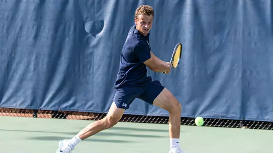 Matthieu Chambonniere turns his shoulders to hit a backhand during a match.