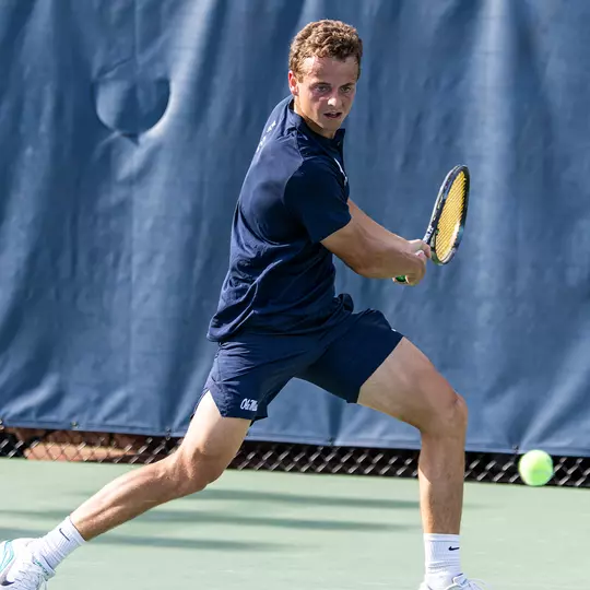 Matthieu Chambonniere turns his shoulders to hit a backhand during a match.
