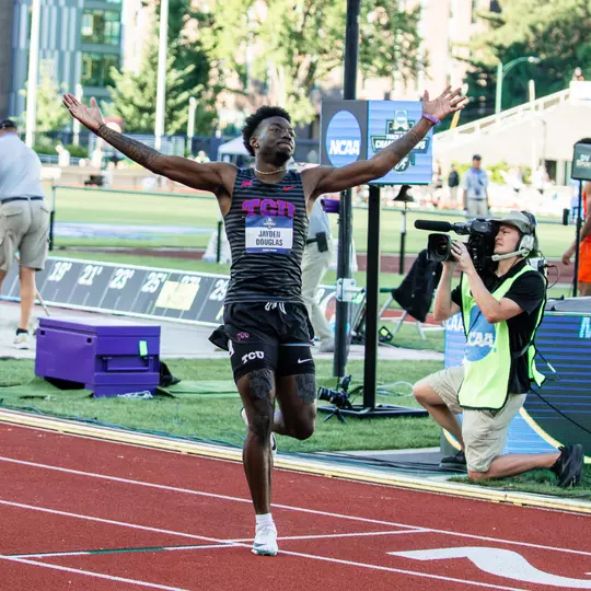 TCU track and field's Jayden Douglas run across the finish line and celebrates after breaking the school record in the 400m hurdles