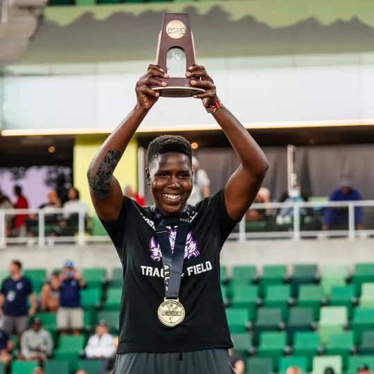 Irene Jepkemboi holds a trophy over her head after finishing third in the javelin throw