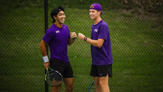 Duncan Chan and Cosme Rolland De Ravel fist bump after winning a point in a doubles match.