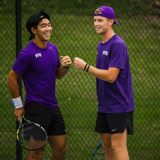 Duncan Chan and Cosme Rolland De Ravel fist bump after winning a point in a doubles match.