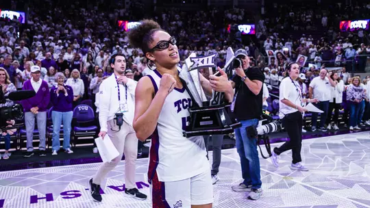 Olivia Miles hoists the Big 12 Championship trophy in front of more than 6,000 fans at Schollmaier Arena.