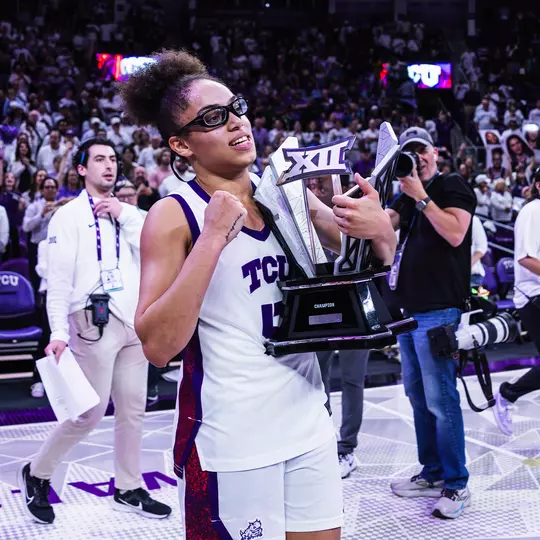 Olivia Miles hoists the Big 12 Championship trophy in front of more than 6,000 fans at Schollmaier Arena.