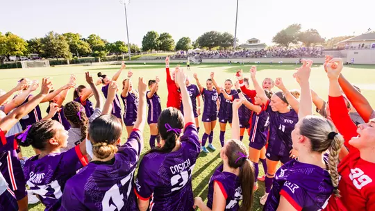 TCU women's soccer team throwing up Frog sign