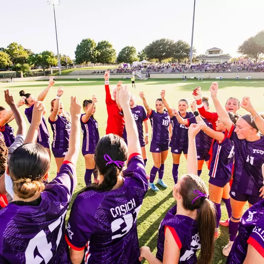 TCU women's soccer team throwing up Frog sign