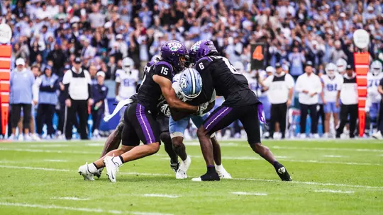Group of TCU defenders tackling a North Carolina player