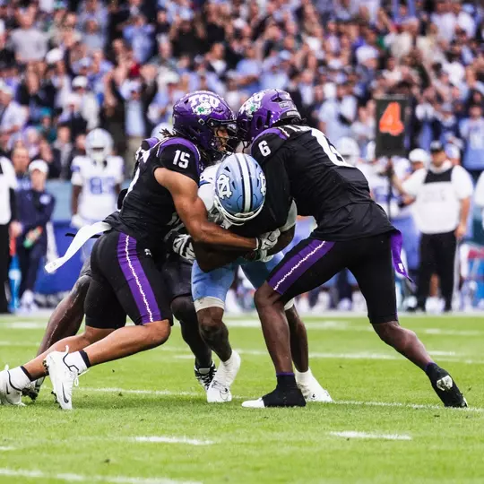 Group of TCU defenders tackling a North Carolina player