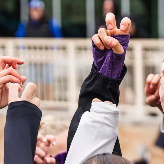 TCU beach volleyball players with the Frog Sign