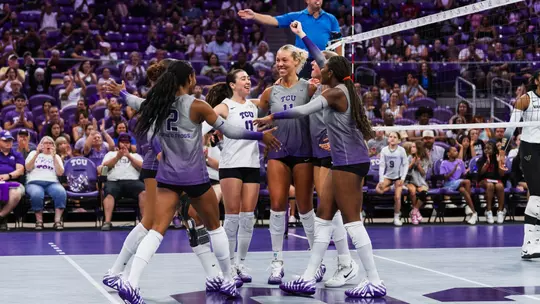 TCU Volleyball huddles together and celebrates a point
