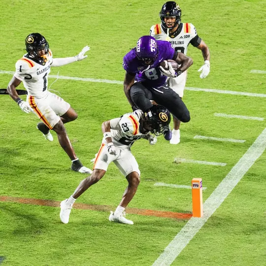 Kari Ashley hurdling a Grambling State player at the goal line