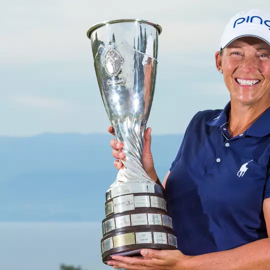 Angela Stanford holds the silver Evian Championship trophy wearing a blue shirt