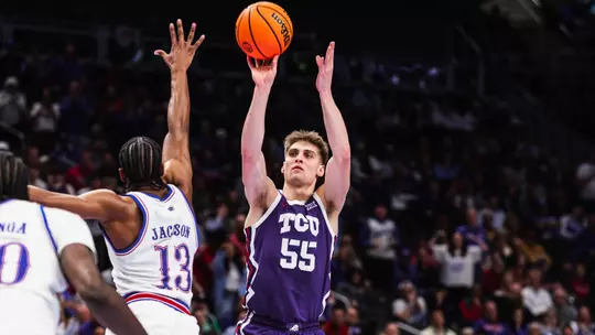 Tanner Toolson shoots the ball over Kansas defender at the Big 12 Tournament