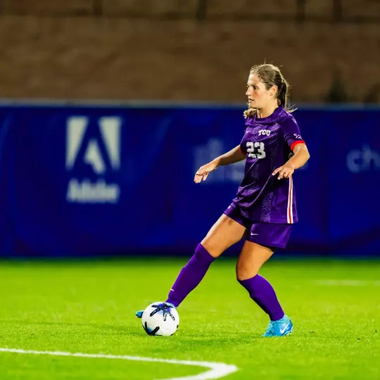 Grace Coppinger with possesion of ball looking for passing target
