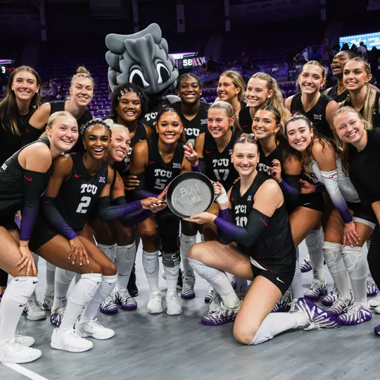 TCU Volleyball celebrates a win over SMU with an iron skillet that reads "Beat SMU"