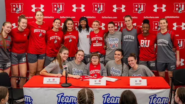Photo of the BU Women's Basketball team posing for a photo with Team IMPACT signee Serena.